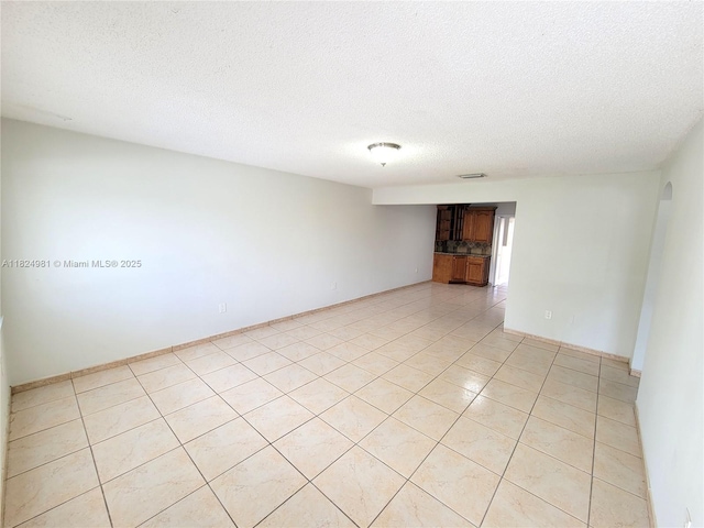 1800 SW 97th Ave, Miramar, FL 33025 - empty room featuring a textured ceiling, arched walkways, and light tile patterned flooring