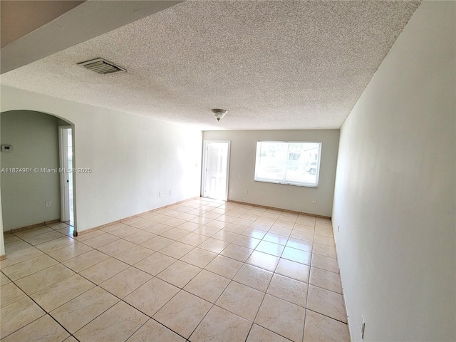 1800 SW 97th Ave, Miramar, FL 33025 - empty room with light tile patterned floors, arched walkways, and a textured ceiling