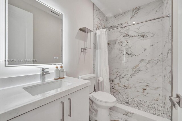 1101 NE 16th Ter Unit 1, Fort Lauderdale, FL 33304 - bathroom featuring a marble finish shower, vanity, and marble finish flooring