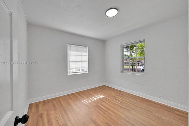 1355 NW 121st St, North Miami, FL 33167 - empty room with light wood-style flooring and baseboards