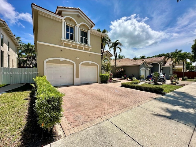 11360 NW 48th Ter, Doral, FL 33178 - mediterranean / spanish home featuring an attached garage, decorative driveway, and stucco siding