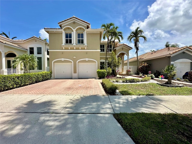 11360 NW 48th Ter, Doral, FL 33178 - mediterranean / spanish house featuring decorative driveway, stucco siding, a garage, and a tiled roof