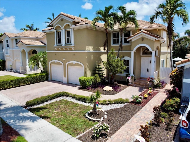 11360 NW 48th Ter, Doral, FL 33178 - mediterranean / spanish-style home with driveway, stucco siding, an attached garage, and a tile roof