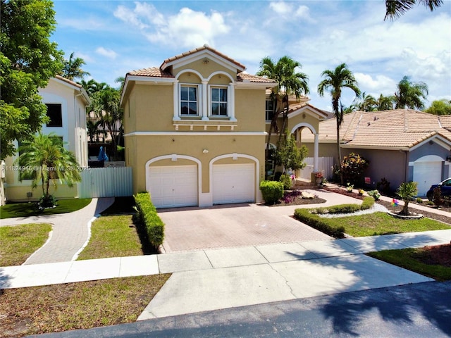 11360 NW 48th Ter, Doral, FL 33178 - mediterranean / spanish-style home featuring decorative driveway, stucco siding, a garage, and a tile roof