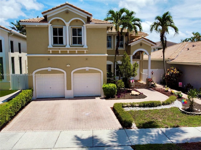 11360 NW 48th Ter, Doral, FL 33178 - mediterranean / spanish house featuring an attached garage, stucco siding, decorative driveway, and a tiled roof