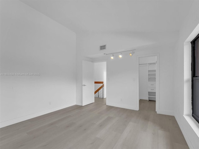 3427 Atlanta Dr, Hollywood, FL 33021 - unfurnished room featuring vaulted ceiling, light wood-style floors, and rail lighting