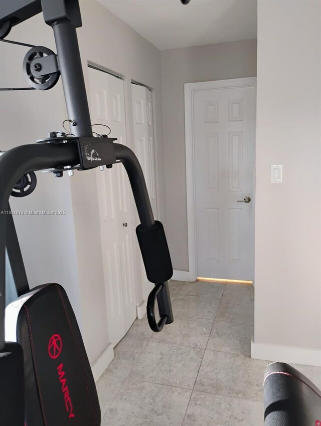 6900 Bay Dr Unit 11K, Miami Beach, FL 33141 - workout room featuring baseboards and light tile patterned floors