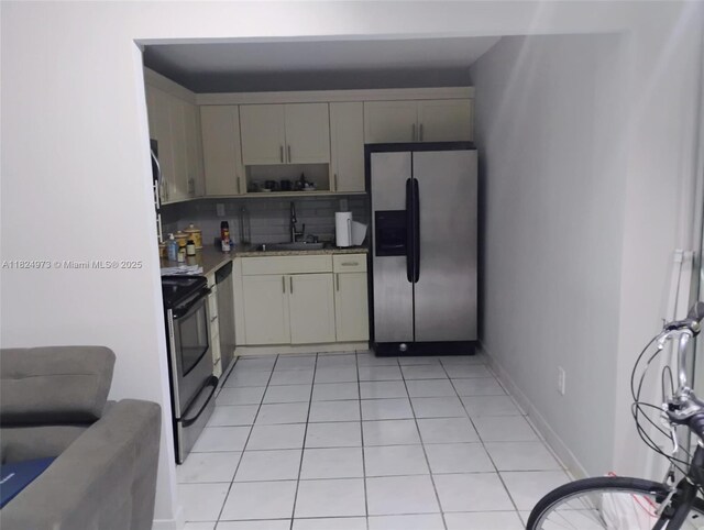 6900 Bay Dr Unit 11K, Miami Beach, FL 33141 - kitchen featuring stainless steel appliances, open shelves, tasteful backsplash, light countertops, and light tile patterned flooring