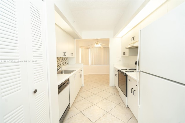 901 SW 141st Ave Unit 303M, Pembroke Pines, FL 33027 - kitchen with white appliances, light countertops, under cabinet range hood, light tile patterned flooring, and white cabinets