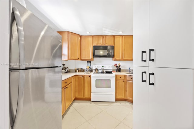 114 Royal Park Dr Unit 2B, Oakland Park, FL 33309 - kitchen featuring freestanding refrigerator, white electric range oven, black microwave, light countertops, and recessed lighting
