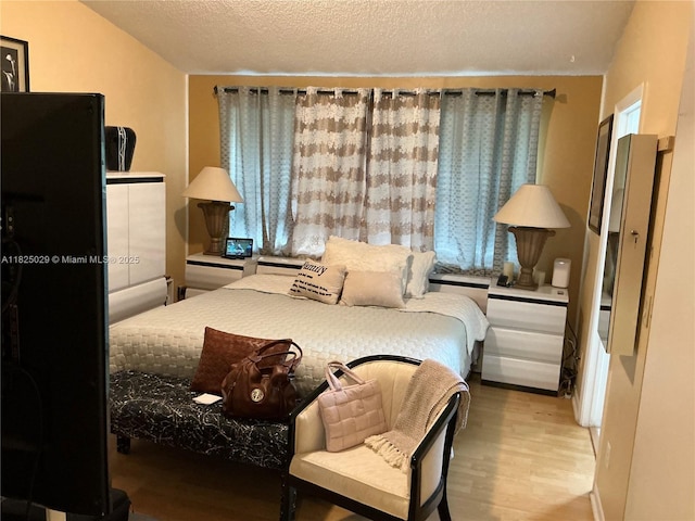 4925 W Lakes Dr, Deerfield Beach, FL 33442 - bedroom with light wood-type flooring and a textured ceiling