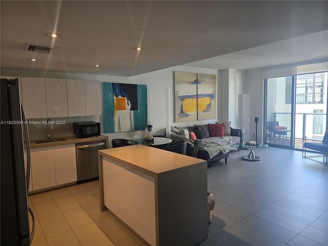 1600 NE 1st Ave Unit 3017, Miami, FL 33132 - kitchen with freestanding refrigerator, stainless steel dishwasher, open floor plan, black microwave, and light countertops