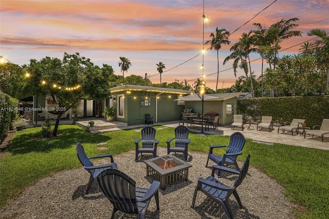 441 SW 27th Rd, Miami, FL 33129 - back of house at dusk with a fire pit, a patio area, a yard, and stucco siding