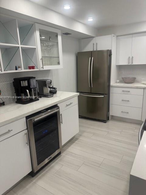 6039 Collins Ave Unit 1516, Miami Beach, FL 33140 - kitchen with freestanding refrigerator, wine cooler, white cabinetry, and light countertops