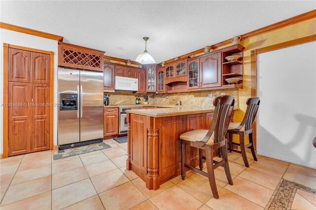 12350 NW 7th Trl, Miami, FL 33182 - kitchen with stainless steel appliances, a peninsula, light countertops, decorative backsplash, and glass insert cabinets