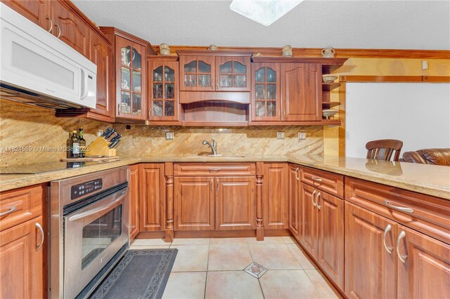 12350 NW 7th Trl, Miami, FL 33182 - kitchen featuring white microwave, stainless steel oven, open shelves, light stone counters, and backsplash