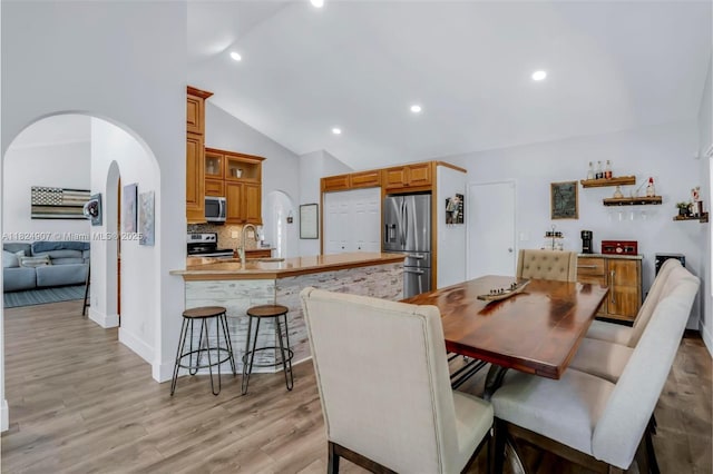 15904 W Wind Cir, Sunrise, FL 33326 - dining area featuring lofted ceiling, arched walkways, recessed lighting, light wood finished floors, and a dry bar