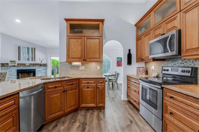 15904 W Wind Cir, Sunrise, FL 33326 - kitchen with appliances with stainless steel finishes, lofted ceiling, light wood-style floors, tasteful backsplash, and light stone countertops