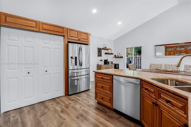 15904 W Wind Cir, Sunrise, FL 33326 - kitchen with stainless steel appliances, brown cabinetry, recessed lighting, wood finished floors, and light stone countertops