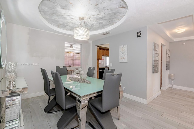 11700 Sheridan St, Pembroke Pines, FL 33026 - dining space featuring a raised ceiling and light wood-style floors