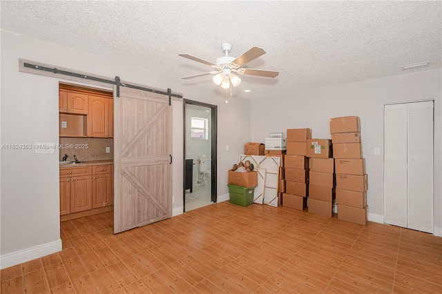 11700 Sheridan St, Pembroke Pines, FL 33026 - unfurnished room featuring a barn door, a ceiling fan, a textured ceiling, and light wood-type flooring