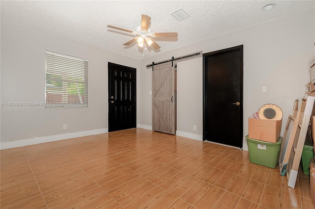 11700 Sheridan St, Pembroke Pines, FL 33026 - unfurnished bedroom with a barn door, a textured ceiling, and a ceiling fan