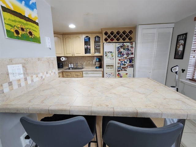 5328 W 26th Ave Unit 112, Hialeah, FL 33016 - kitchen with white appliances, a breakfast bar, a peninsula, glass insert cabinets, and decorative backsplash