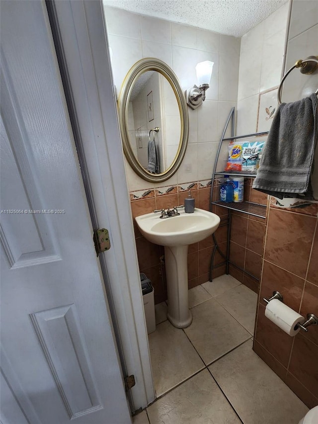 5328 W 26th Ave Unit 112, Hialeah, FL 33016 - bathroom featuring tile walls, a textured ceiling, tile patterned flooring, and tasteful backsplash