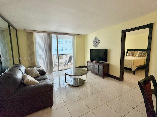 6039 Collins Ave Unit 923, Miami Beach, FL 33140 - living area with a wall of windows and light tile patterned floors