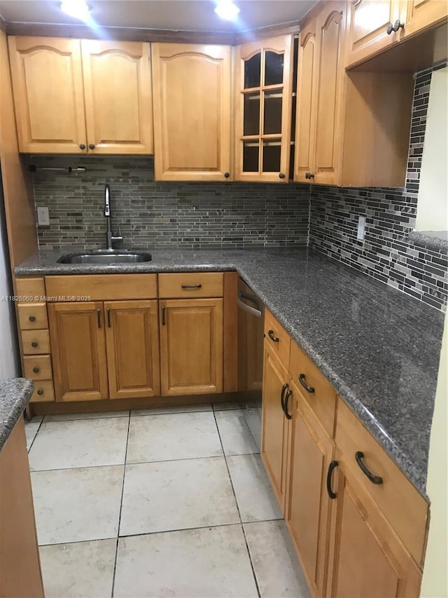 1145 Normandy Dr Unit 304, Miami Beach, FL 33141 - kitchen featuring backsplash, glass insert cabinets, light tile patterned floors, and dark stone counters