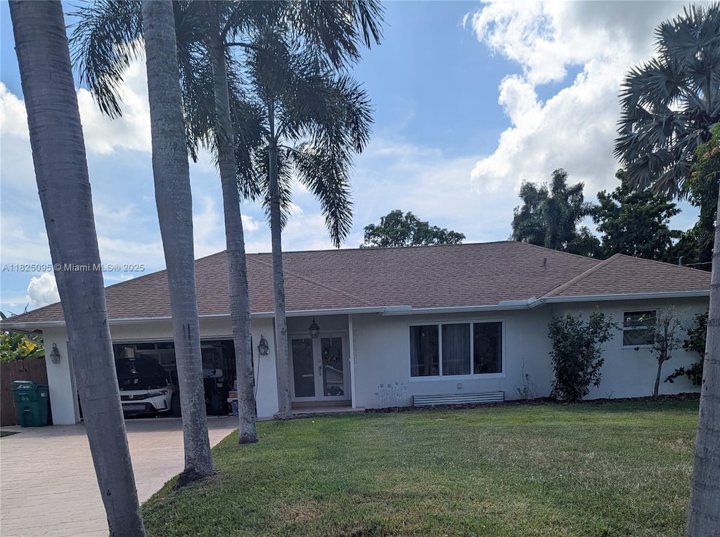 2171 NW 123rd Ave, Plantation, FL 33323 - view of front of home with driveway, stucco siding, a front yard, roof with shingles, and an attached garage