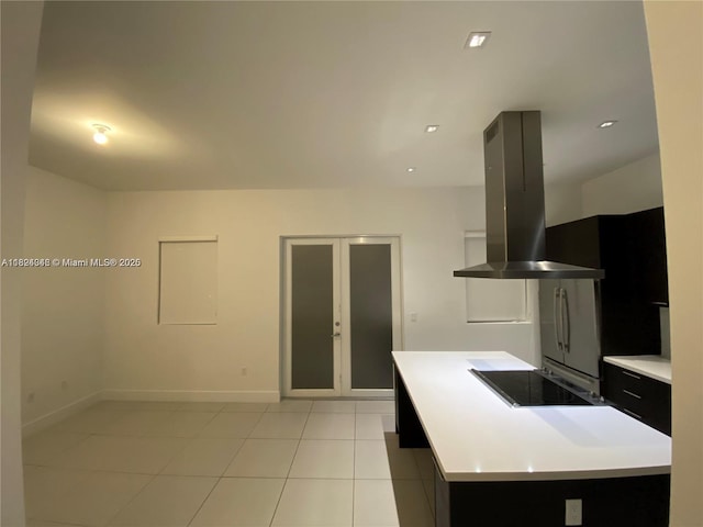 9181 NW 33rd St Unit 9181, Doral, FL 33172 - kitchen featuring exhaust hood, black electric stovetop, light countertops, light tile patterned flooring, and freestanding refrigerator