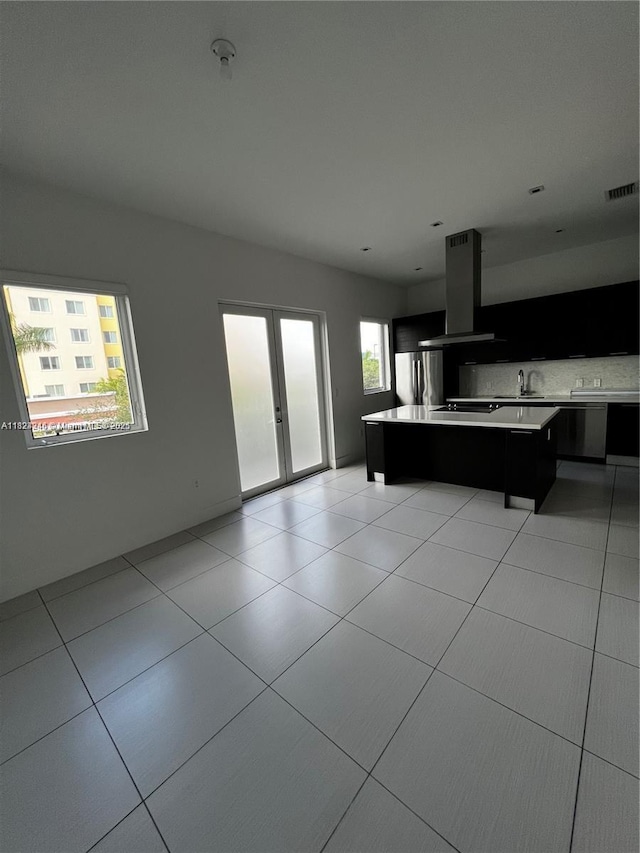 9181 NW 33rd St Unit 9181, Doral, FL 33172 - kitchen with island exhaust hood, freestanding refrigerator, light countertops, dark cabinetry, and a kitchen island
