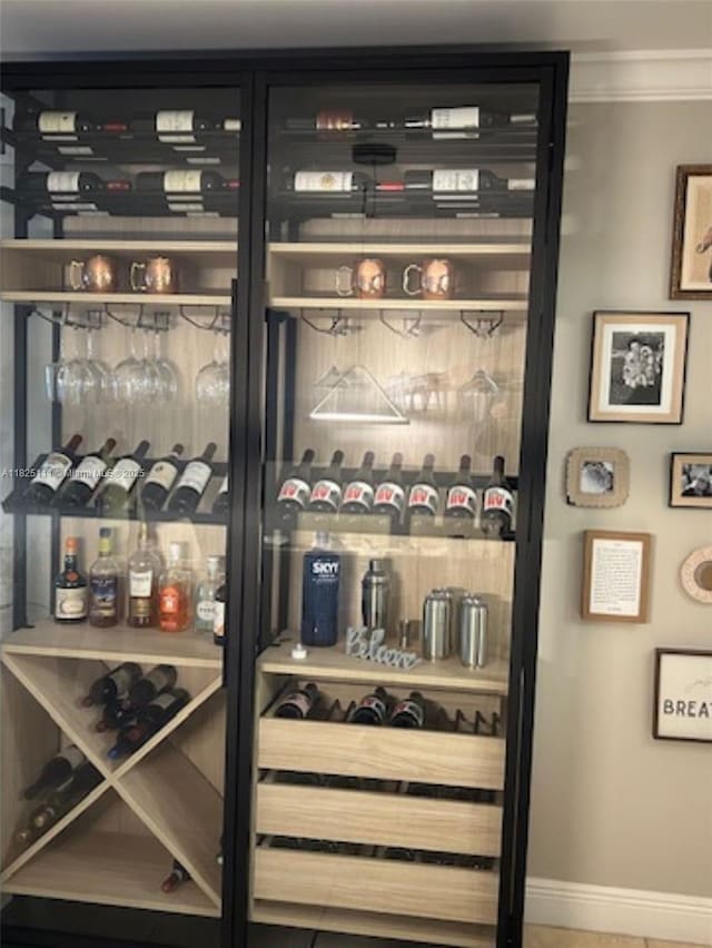 300 Golden Isles Dr Unit 311, Hallandale Beach, FL 33009 - wine area featuring crown molding and baseboards