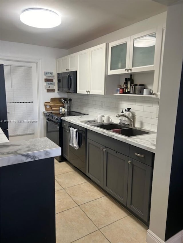 300 Golden Isles Dr Unit 311, Hallandale Beach, FL 33009 - kitchen with black appliances, light tile patterned flooring, tasteful backsplash, open shelves, and white cabinets
