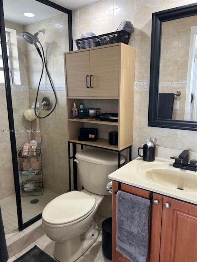 300 Golden Isles Dr Unit 311, Hallandale Beach, FL 33009 - bathroom featuring tile walls, a stall shower, vanity, and tile patterned floors