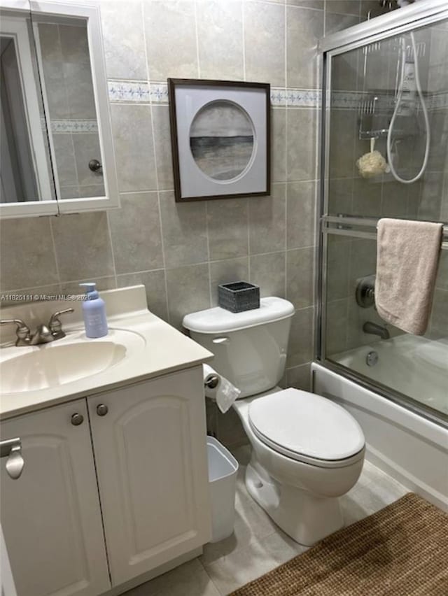 300 Golden Isles Dr Unit 311, Hallandale Beach, FL 33009 - bathroom with tile walls, vanity, and bath / shower combo with glass door