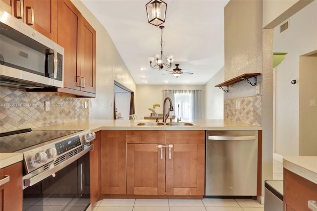 453 Lakewood Cir Unit A, Margate, FL 33063 - kitchen featuring stainless steel appliances, a chandelier, decorative backsplash, light countertops, and a peninsula