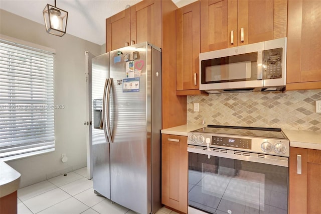 453 Lakewood Cir Unit A, Margate, FL 33063 - kitchen with appliances with stainless steel finishes, light tile patterned floors, brown cabinets, and light countertops