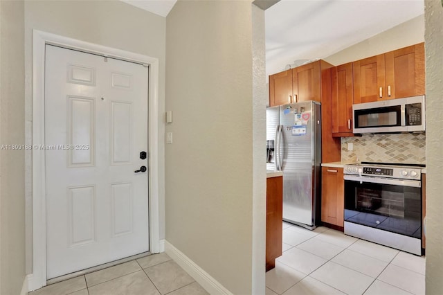 453 Lakewood Cir Unit A, Margate, FL 33063 - kitchen with stainless steel appliances, light tile patterned floors, light countertops, tasteful backsplash, and brown cabinetry