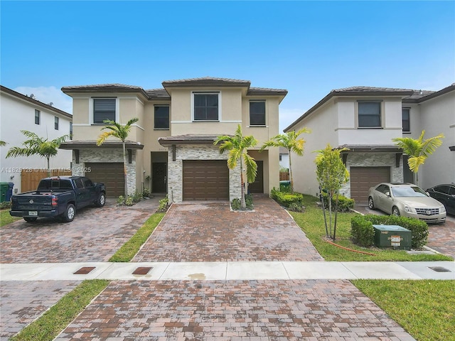 25564 SW 108th Ave, Homestead, FL 33032 - view of front of house featuring driveway, stucco siding, a garage, a tiled roof, and stone siding