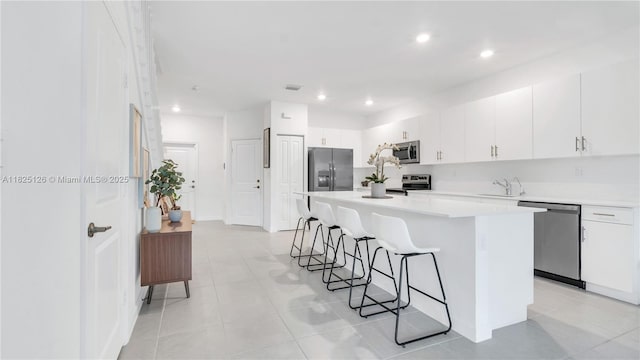 25564 SW 108th Ave, Homestead, FL 33032 - kitchen featuring appliances with stainless steel finishes, a breakfast bar, a kitchen island, light countertops, and recessed lighting