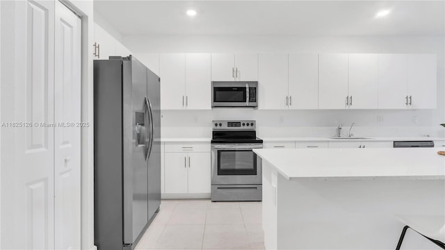 25564 SW 108th Ave, Homestead, FL 33032 - kitchen with stainless steel appliances, light countertops, white cabinetry, recessed lighting, and light tile patterned floors