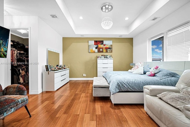 3521 Forest View Cir, Dania Beach, FL 33312 - bedroom with light wood-type flooring, a raised ceiling, a spacious closet, a chandelier, and recessed lighting