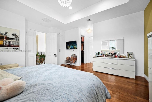 3521 Forest View Cir, Dania Beach, FL 33312 - bedroom with wood finished floors, a tray ceiling, a walk in closet, a chandelier, and recessed lighting