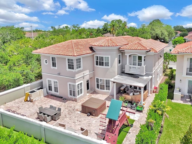 3521 Forest View Cir, Dania Beach, FL 33312 - rear view of house with a hot tub, a patio, a fenced backyard, a tiled roof, and outdoor dining area