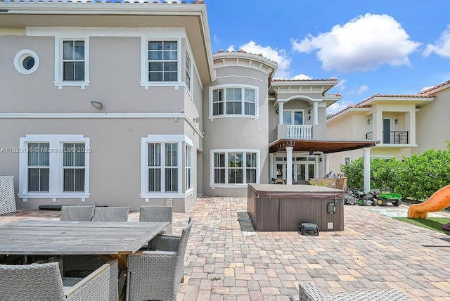 3521 Forest View Cir, Dania Beach, FL 33312 - rear view of property with a hot tub, a patio, stucco siding, and outdoor dining space