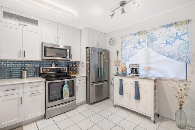 5725 Pelican Pointe, Sebastian, FL 32958 - kitchen featuring appliances with stainless steel finishes, tasteful backsplash, light countertops, white cabinets, and light tile patterned flooring