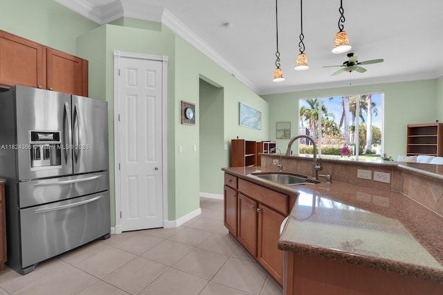 819 SW Bromelia Ter, Stuart, FL 34997 - kitchen with stainless steel fridge, crown molding, brown cabinetry, ceiling fan, and hanging light fixtures