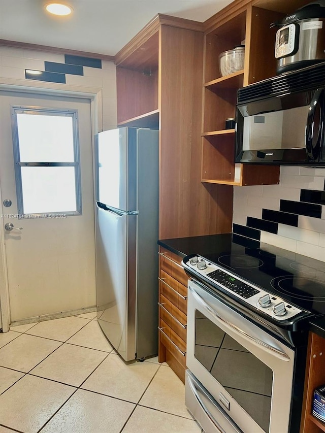 930 SE 9th Ave Unit 11, Pompano Beach, FL 33060 - kitchen featuring appliances with stainless steel finishes, open shelves, light tile patterned flooring, and dark countertops